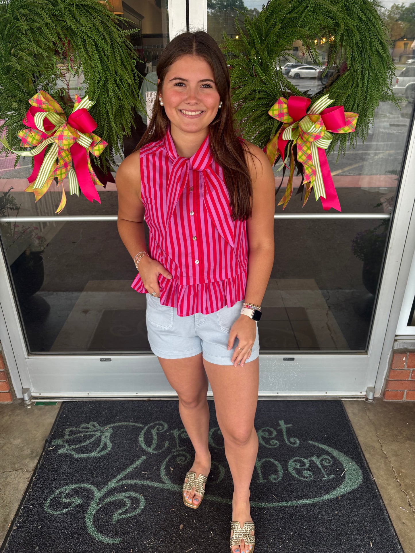 Striped sleeveless peplum top featuring tie neck detail